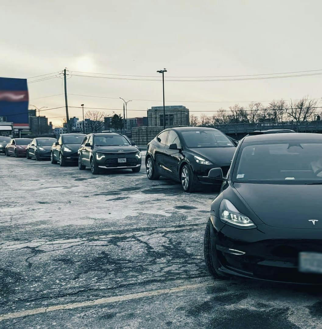 EVs waiting in line to charge at a public charger.